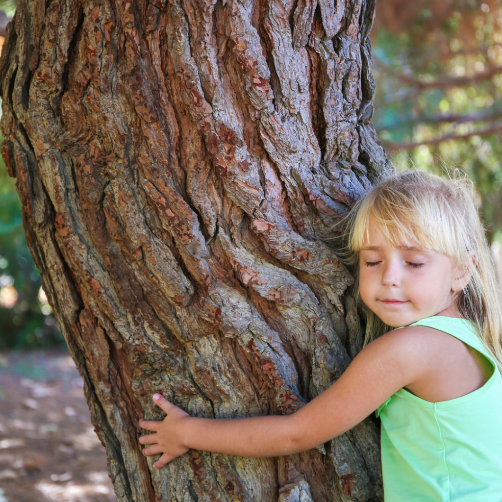 Child embracing a tree symbolizing inner child healing and connection to nature.