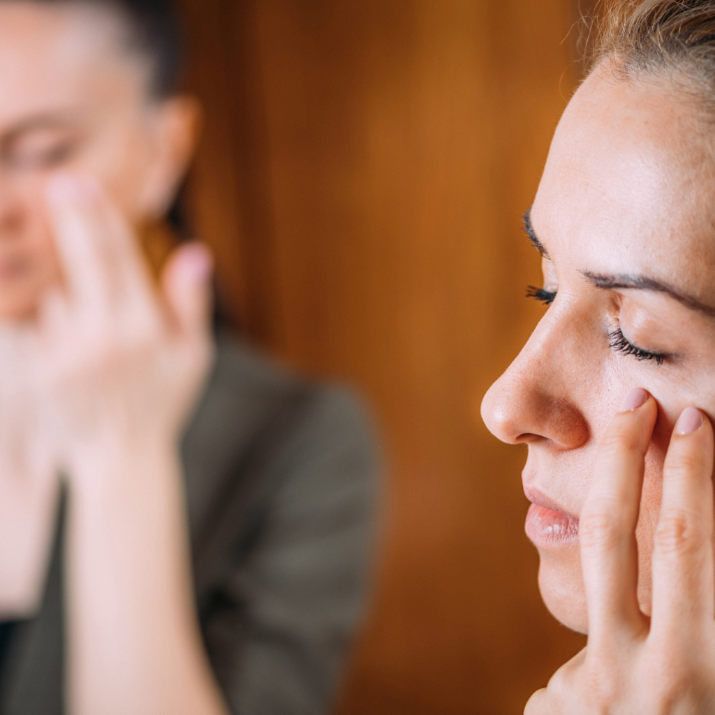 Woman Practicing EFT Tapping on Meridian Points Under Eyes